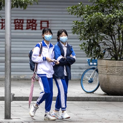 Students wear protective face masks while walking in Guangzhou, the capital of Guangdong, on Wednesday. Some schools in the city have started to resume. Photo: EPA-EFE