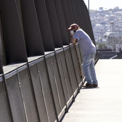 A man wearing a face mask looks at the US-Mexico border from a bridge in the district of San Ysidro in San Diego, California, on April 22. Rich countries can close their borders, but if the pandemic rages on in the poor, overpopulated countries, the virus will continue to circulate. Photo: EPA-EFE