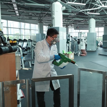 HKUST-CIL adviser Hamilton Hung sprays Germagic disinfectant on surfaces of the gym of the Hong Kong Sports Institute. Photo: Germagic