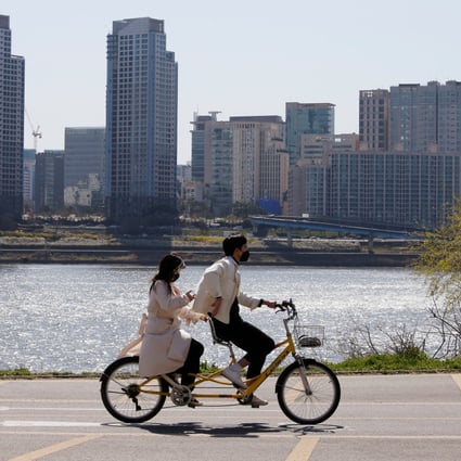 A couple wearing masks take a ride in Han River Park, in Seoul, South Korea, on April 4. The country emerged as one of the world’s most actively traded commercial property markets last year. Photo: Reuters