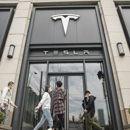 Pedestrians walk past a Tesla dealership in Shanghai, China on Monday, April 6, 2020. Photo: Bloomberg