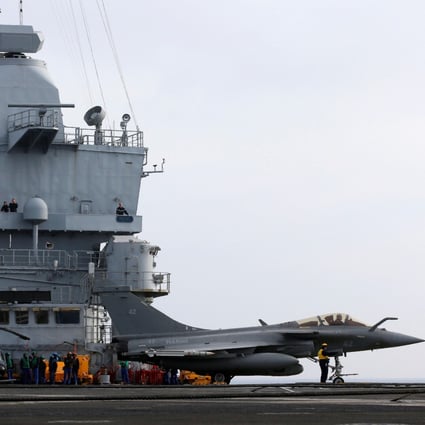 Flight deck crew members direct a French Rafale fighter jet on the French aircraft carrier Charles de Gaulle in the Mediterranean sea. Photo: reuters