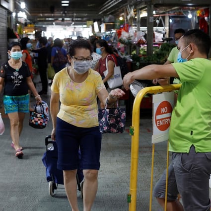 A woman has her hands sanitised while buying groceries amid the coronavirus outbreak in Singapore. Photo: Reuters