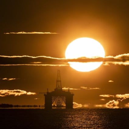 The sun rises behind an oil platform. Photo: PA Wire via dpa