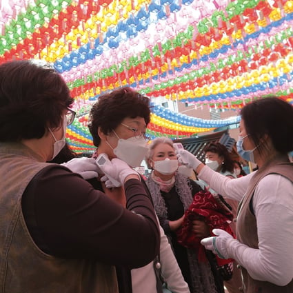 Devotees receive temperature check as they arrive to celebrate Buddha’s birthday at the Chogyesa temple in Seoul. Photo: AP
