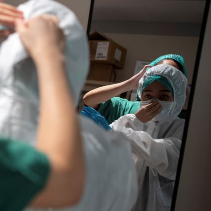 A nurse at a Bangkok hospital receives help from a colleague putting on her protective suit before attending to Covid-19 patients on April 22. Women are not just taking care of their own families, but are also active on the Covid-19 front lines. Worldwide, 70 per cent of health and social service providers are women. Photo: Reuters