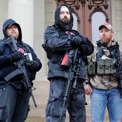 Armed protesters provide ‘security’ on the steps of the Michigan State Capitol in Lansing, demanding the reopening of businesses. Photo: AFP