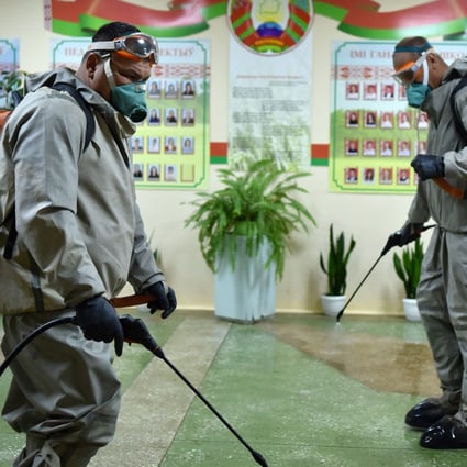 Belarus servicemen wearing protective gear disinfect a school outside Minsk. Photo: AFP