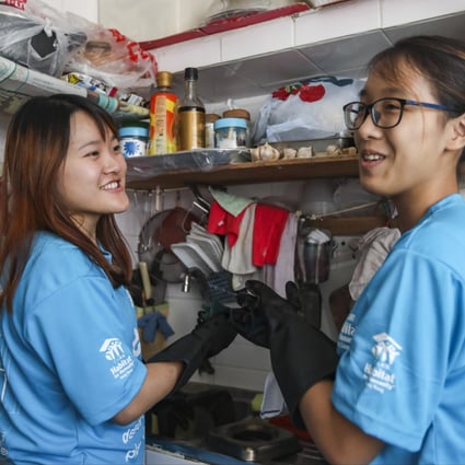 Two student volunteers from The Education University of Hong Kong, Rose Tsui (left) and Katherine Ho, help clean the home of an elderly lady in Kai Yip Estate in Kowloon Bay. Photo: Xiaomei Chen