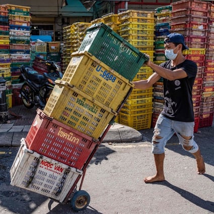 A worker pushes crates at a fruit market in Kuala Lumpur on May 4, 2020. Photo: AFP