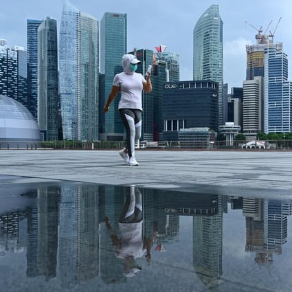 A woman, wearing a face mask as a preventive measure against the spread of the coronavirus, walks along the promenade at Marina Bay in Singapore on May 4. Photo: AFP