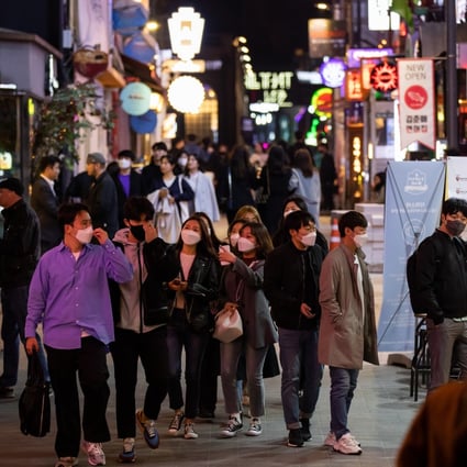 People wearing protective face masks walk through the Itaewon district in Seoul. South Korea reported a cluster of new cases linked to nightclubs in the popular area. Photo: Bloomberg