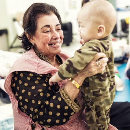 Purviz Shroff takes a baby in her arms at teen pregnancy charity Mother’s Choice in Mid-Levels, Hong Kong. She has helped launched the new “Our Hong Kong Family” initiative to encourage the community to help with a huge rise in demand for the charity’s services. Photo: Purviz Shroff