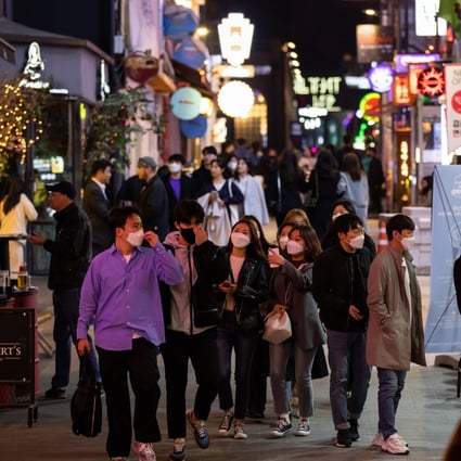 People wearing protective face masks walk through the Itaewon district in Seoul. Photo: Bloomberg