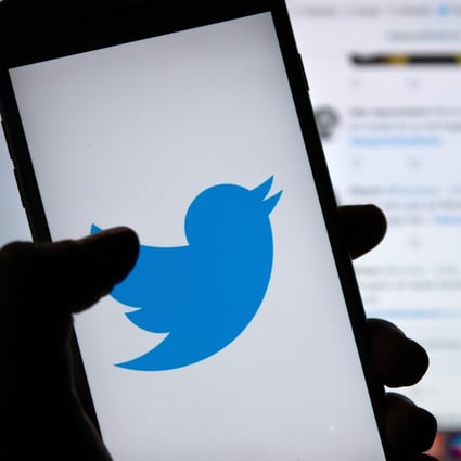 A person holds a phone displaying the logo of the Twitter social media platform. Photo: DPA