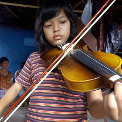 Milton Augustino Michiels and his niece Citra Augusta Margriette (front) play kroncong music at home in Kampung Tugu, Jakarta. A tour company that usually runs guided tours of the urban village has launched a virtual tour of it, and other places of interest in the Indonesian capital, amid the coronavirus pandemic that has halted international travel. Photo: Bay Ismoyo/AFP/Getty Images