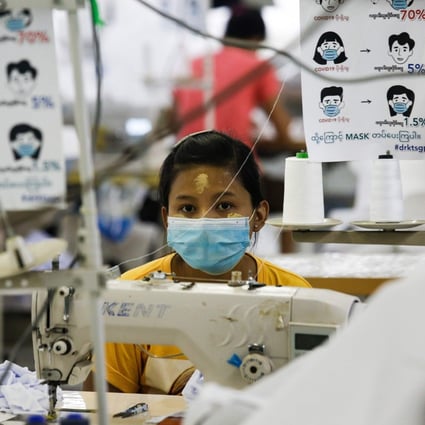 A worker wearing a face mask sews disposable surgical gowns for health workers at a garment factory in Yangon, Myanmar. Photo: AFP