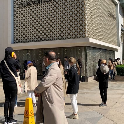People practise social distancing as they queue to enter the Chanel boutique at a department store in Seoul on Wednesday ahead of price rises on some bags and leather goods. Photo: Reuters