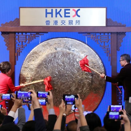 Hong Kong Exchanges and Clearing (HKEx) Chairperson Laura Cha Shih May-lung (left); Hong Kong Financial Secretary Paul Chan Mo-po (right) striking the ceremonial gong on the first trading day of the Lunar New Year on the city’s stock exchange on 8 February 2019. Photo: Felix Wong