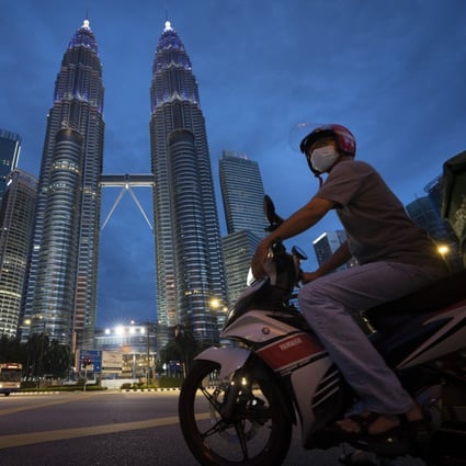 A motorist in front of Kuala Lumpur’s Twin Towers. Photo: AP