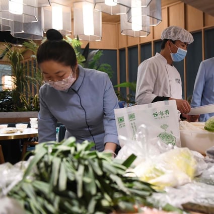 Workers at a restaurant pack vegetables before delivering them to residents in a nearby residential compound in Beijing. Photo: AFP
