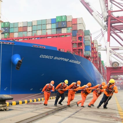 Workers wearing face masks rope a container ship at a port in Qingdao, Shandong province, China, on February 11. Global trade declined by 3 per cent in value during the first quarter of this year. Photo: China Daily via Reuters