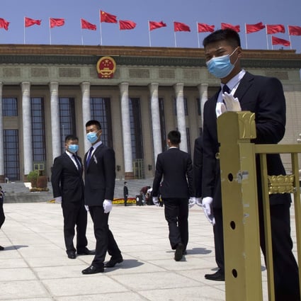 Chinese security officials stand guard outside the Great Hall of the People after the opening session of China's National People's Congress in Beijing on Friday. Photo: AP