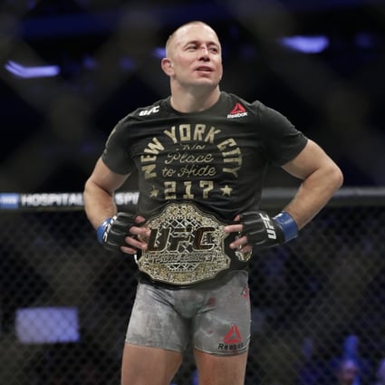 Georges St-Pierre celebrates his middleweight title win against Michael Bisping at UFC 217. Photo: AP