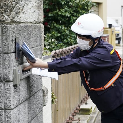 A mail carrier delivers cloth masks in Tokyo in April, during a coronavirus outbreak in Japan. Photo: Kyodo