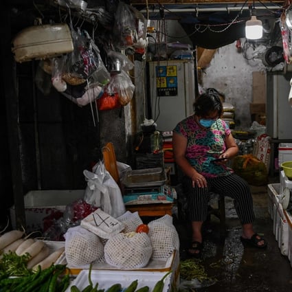 A vendor wearing a face mask sits in her shop in Wuhan, in China’s central Hubei province. Photo: AFP