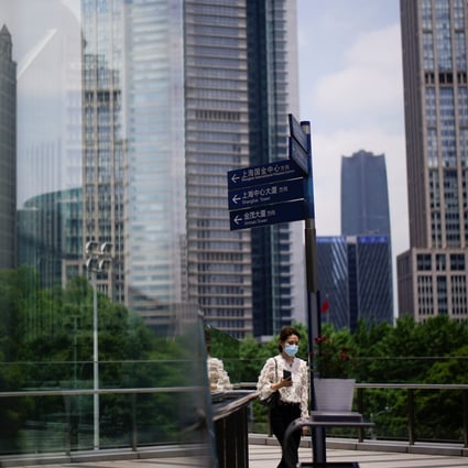 A woman walks through the Lujiazui financial district in Shanghai. In China, women make up 51 per cent of entry-level professionals, but only 22 per cent of middle management and 11 per cent of senior managers. Photo: Reuters