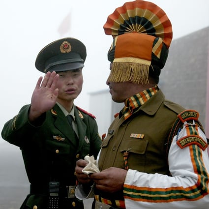 A Chinese soldier gestures next to an Indian soldier at a border crossing between India and China in Sikkim state. Photo: AFP