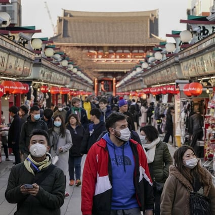 Tourists wearing masks stroll through Tokyo’s Asakusa district, in March. Photo: EPA-EFE
