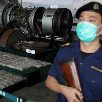A customs officer stands guard in front of the cocaine worth HK$246 million (US$31.7 million) hidden in an aircraft engine. Photo: Nora Tam