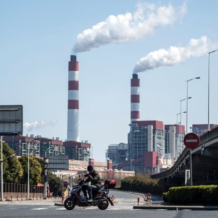 A man rides his scooter near a coal power plant in Shanghai. File photo: AFP