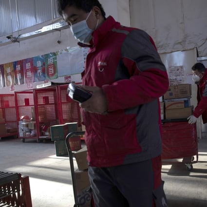 Delivery workers for Chinese e-commerce giant JD.com prepare for the morning round of deliveries from a distribution center in Beijing. Photo: AP