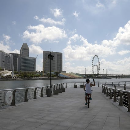 A cyclist rides along the pier at the near-empty Merlion Park in Singapore. Photo: Bloomberg