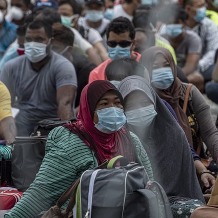 Undocumented migrants sit during a raid in Petaling Jaya near Kuala Lumpur on May 20, 2020. Photo: EPA-EFE