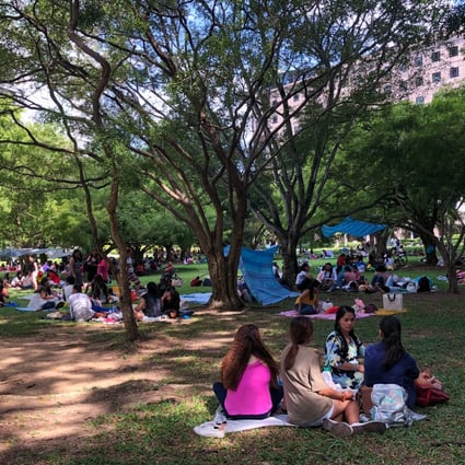 Domestic workers gather on a grass patch behind Somerset MRT Station in Singapore earlier this year. Photo: Kok Xinghui