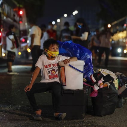 A boy waits for a bus put on to ferry away those stranded in the Philippine capital amid the almost three-month coronavirus lockdown. Photo: AP