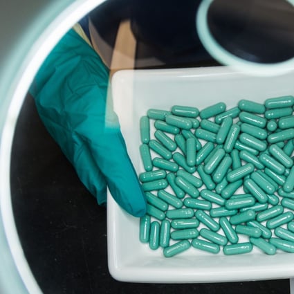 An employee checks the production of capsules at a Stada Arzneimittel durg manufacturing facility in Germany. Photo: dpa