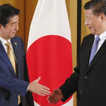 Chinese President Xi Jinping (right) and Japanese Prime Minister Shinzo Abe shake hands at the start of their talks in Osaka in June 2019. Photo: EPA-EFE