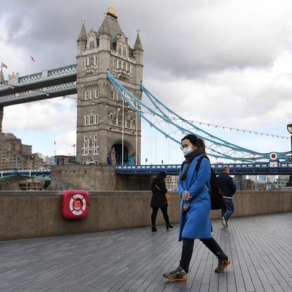 A woman wearing a face mask walks past Tower Bridge in London on March 12. Microsoft Corp, Amazon Web Services and Google are also involved in the health data deal made between Palantir Technologies and Britain’s National Health Service. Photo: EPA-EFE