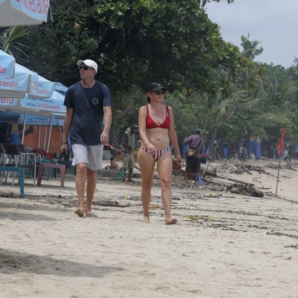 Foreigners walk along an empty Kuta Beach in Bali amid the coronavirus pandemic in March. Photo: AP