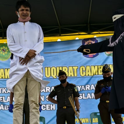 A man receives 100 whippings by religious police in Jantho, Aceh province. Photo: AFP