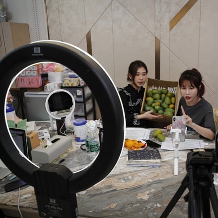 In this May 5, 2020, photo, China's online celebrity Zhang Mofan, right, introduces fresh mangos to her online clients and fans through live-streaming at her house in Beijing. Retailers in China are embracing livestreaming as a sales channel amid a Chinese ‘shoppertainment’ boom accelerated during the Covid-19 pandemic. Photo: AP