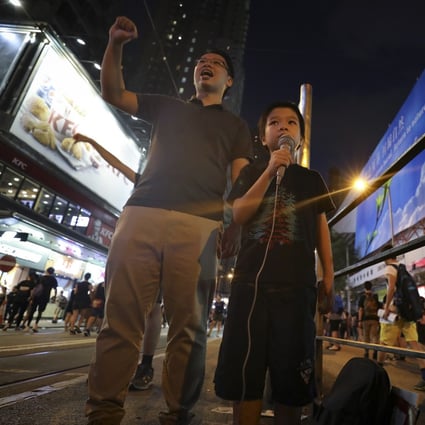 A father (left) and son chant slogans during a protest through Wan Chai in Hong Kong last year. There is a need for schools, parents and policymakers to work out how best to discuss the global protests in the classroom. Photo: James Wendlinger