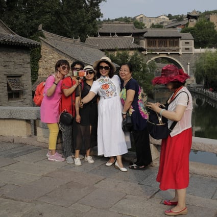 A group of women take a selfie against the ancient village in Gubei Water Town, a popular tourist spot in Beijing, on June 9. Some 59 per cent of mainland Chinese in a recent survey said they worry about travelling now, and a new outbreak of coronavirus has been reported in Beijing. Photo: Associated Press
