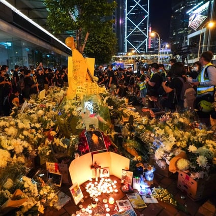Mourners at Pacific Place mall offer flowers at a shrine. Photo: Felix Wong