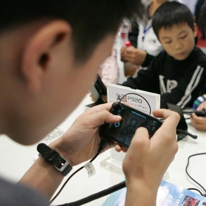 Chinese kids play mobile games on smartphones during an expo in Chengdu city, Sichuan province, on 20 October 2011. Photo: Imaginechina